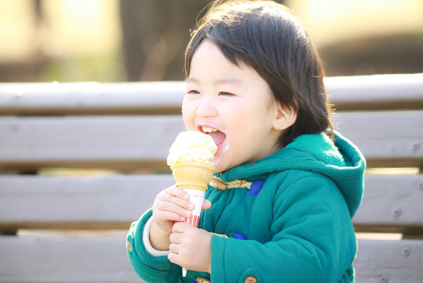 cute little boy eating ice cream in the park - Photo, Image