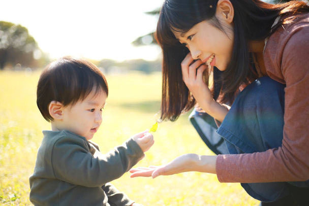 Young asian mother   with her  son  having fun  in the park   - Zdjęcie, obraz
