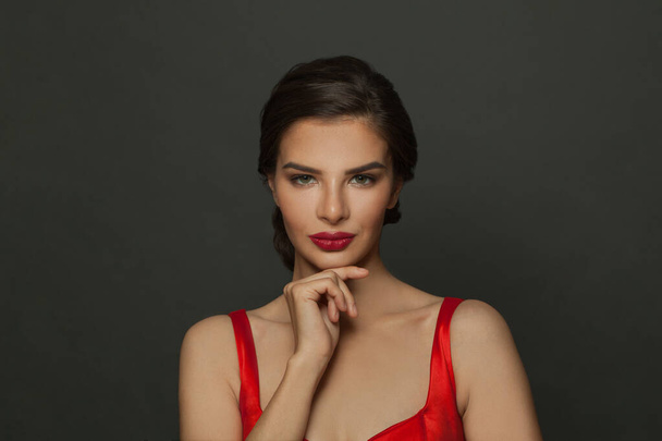 Schönes Frauenporträt. Junge Dame posiert aus nächster Nähe auf schwarzem Hintergrund. Glamour-Make-up, roter Lippenstift - Foto, Bild