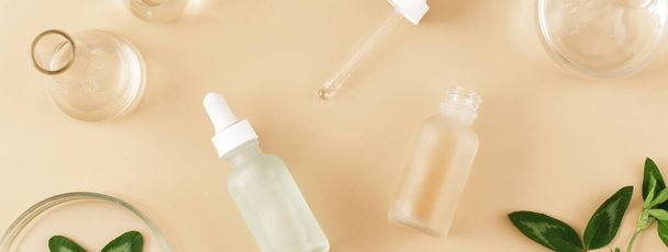 Banner made Laboratory glassware with serum and oil on beige background. Natural medicine, cosmetic research, bio science, organic skin care products. Flat lay, top view. - Foto, Bild