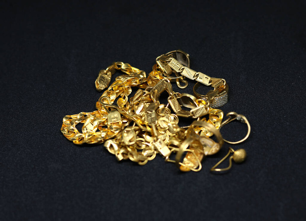золотые украшения с золотой цепи кольцо серьги с черным фоном - Фото, изображение