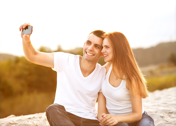 Loving couple taking selfie in the park - Фото, изображение