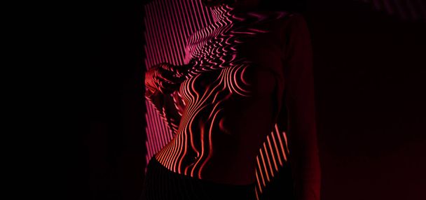 Sexy womens body with red light linear pattern. Nude photoshoot with a projector. - Valokuva, kuva