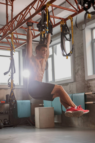 Junger sportlicher Mann trainiert im Fitnessstudio - Foto, Bild