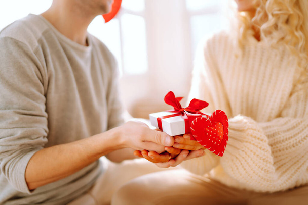 Valentine's Day concept. Exchange of gifts. Beautiful young couple at home celebrating Valentine's Day. Romantic day. - Foto, immagini