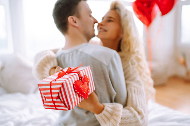 Valentine's Day concept. Exchange of gifts. Beautiful young couple at home celebrating Valentine's Day. Romantic day. - Valokuva, kuva