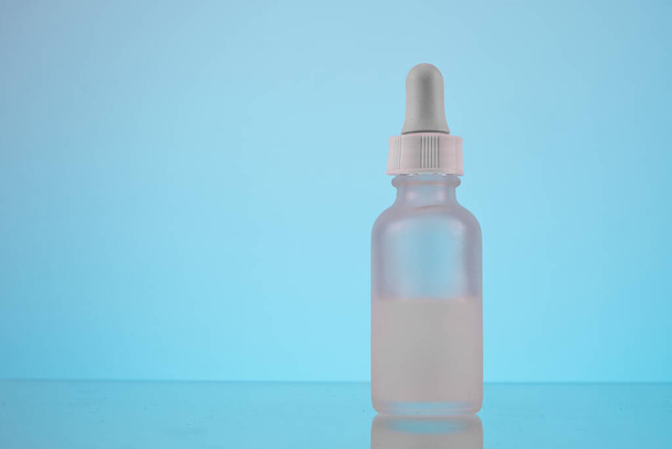 face serum oil dropper glass bottle with pipette on blue background close up - Photo, Image