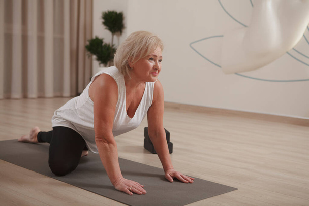 Active senior woman enjoying stretching at sport studio, copy space - Фото, зображення