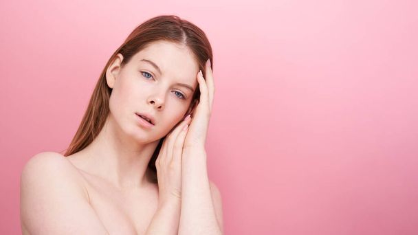 Close-up shot of young woman on pink background.  - Фото, изображение