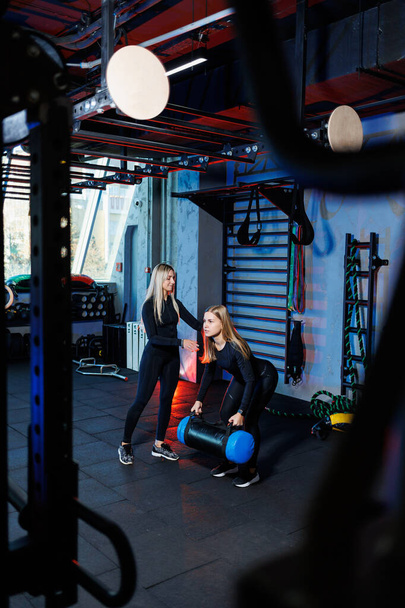 Urheilu, kunto, kehonrakennus, elämäntapa ja harjoitus konsepteja nainen tekee urheilua tiukassa ohjauksessa kouluttaja kuntosalilla, työskentelevät lihaksia kuntosalilla - Valokuva, kuva