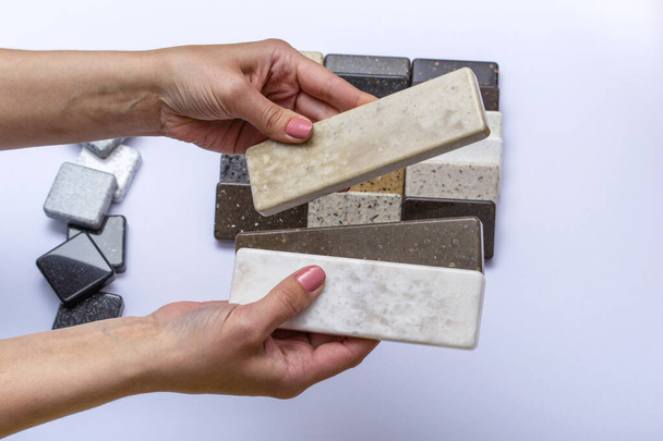 Mock up from natural stones, top view, close up. Female hands advertises repair materials. Floor tiles, tiles, countertops. - Φωτογραφία, εικόνα