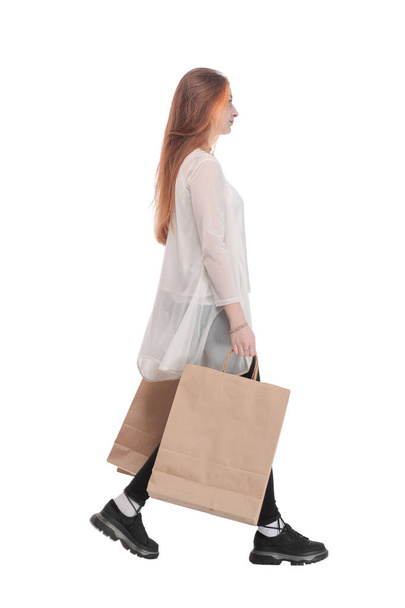 Side view of going beautiful girl with shopping bags. - Fotó, kép