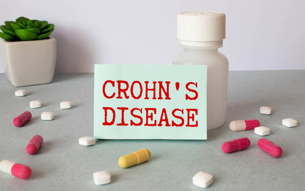 Crohn's Disease - Diagnosis written on a piece of white paper with medication and Pills. - Photo, image