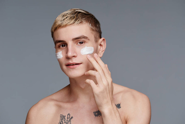 Hombre joven con crema facial Mínimo - Foto, Imagen