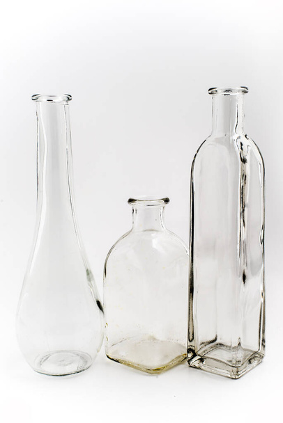 three empty glass vintage bottles on a white background. - Photo, image