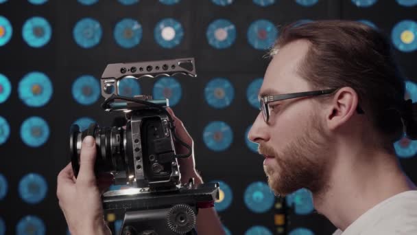 Видеограф устанавливает камеру для съемки в студии и комментирует. - Кадры, видео