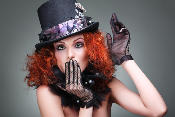 Portrait of beautiful sexual redheaded girl in a black hat on a grey background. Accessories. - Zdjęcie, obraz