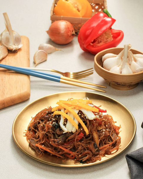 Korean traditional Food. Stir Fried Glass Noodle with Soy Sauce Called Japchae or  Chapchae. Served on Golden Plate - Valokuva, kuva