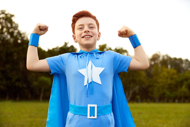Strong superhero boy showing power - Foto, Imagen