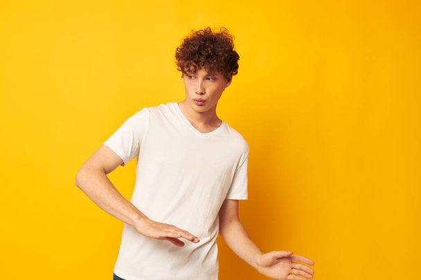 red-haired guy in a white t-shirt on a yellow background - Foto, afbeelding