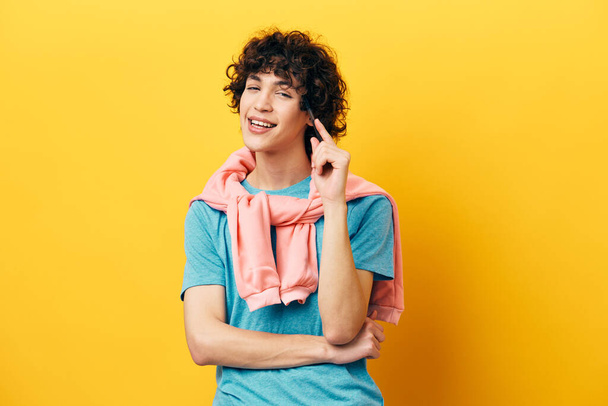 curly guy in a blue T-shirt idea pink jacket yellow background - Photo, Image