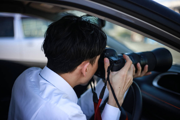 мужчина в машине с камерой, фотографирующий - Фото, изображение