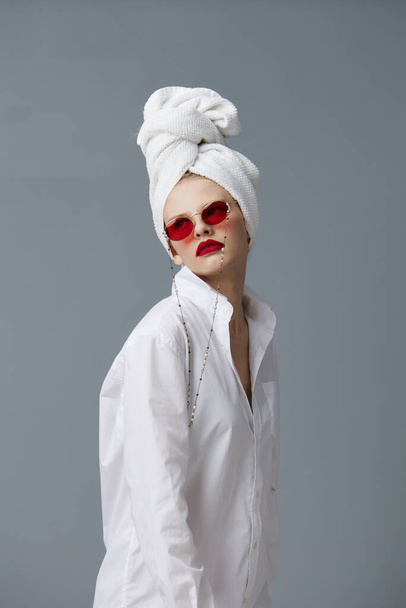 pretty woman red sunglasses cosmetics with towel on head Gray background - Foto, imagen