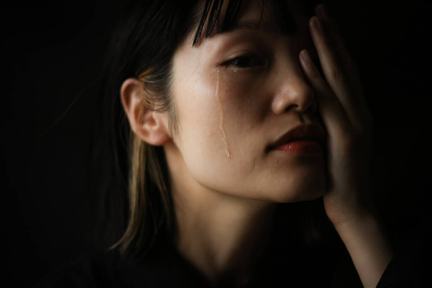 Koyu arkaplanda ağlayan Japon kadının portresi  - Fotoğraf, Görsel