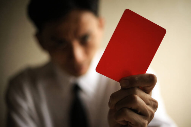 Asian male employee issuing a red card - Фото, зображення