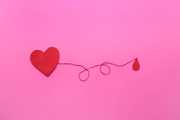 Punainen paperi sydän ja pisara verta värillinen tausta. Lahjoituskäsite - Valokuva, kuva