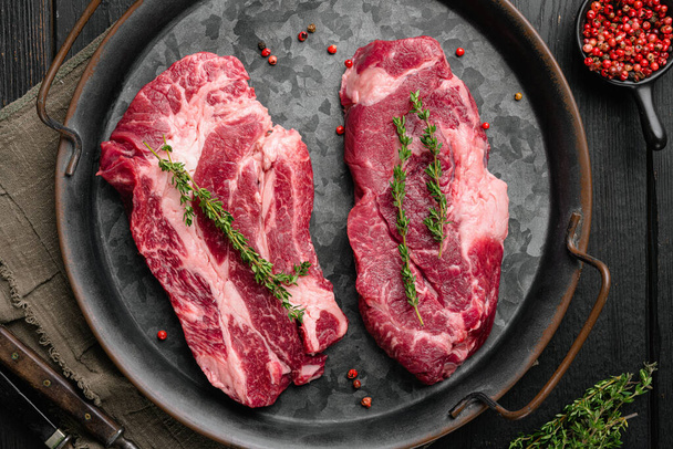 Rohe Chuck-Eye-Roll-Steaks. Bio-Rindfleisch-Set, auf schwarzem Holztischhintergrund, von oben flach gelegt - Foto, Bild