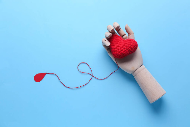 Ahşap bir el, örgü bir kalp ve renkli arka planda kağıt bir kan damlası. Bağış konsepti - Fotoğraf, Görsel