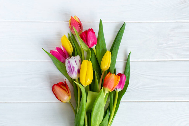 Barevné tulipány květinové složení na bílém dřevěném stole pozadí s kopírovacím prostorem. Láska, Den matek, Den žen a jarní čas květinové pozadí. Jarní příroda pozadí. - Fotografie, Obrázek