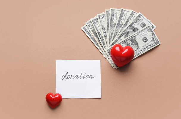 Rote Herzen, Geld und Papier mit Wort DONATION auf farbigem Hintergrund - Foto, Bild