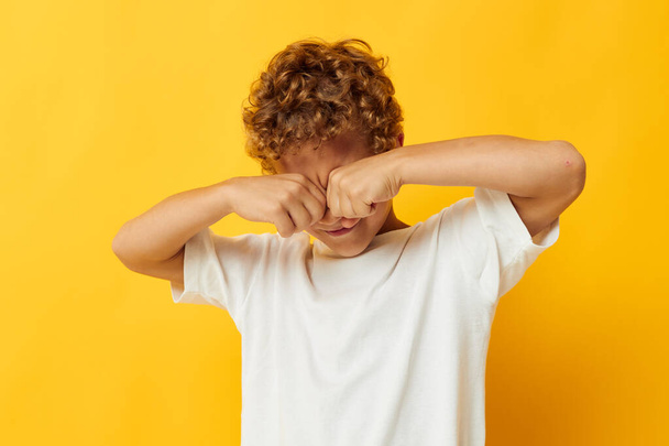 boy with curly hair childhood posing yellow background - Фото, изображение