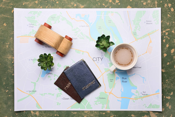 Houten auto, kaart, kopje koffie, kamerplanten en paspoorten op groene achtergrond - Foto, afbeelding