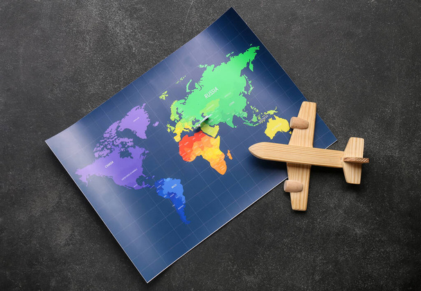 暗い背景に木製の飛行機と世界地図 - 写真・画像