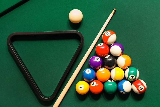 緑のテーブルの上にキューとラックと異なるビリヤードボール - 写真・画像
