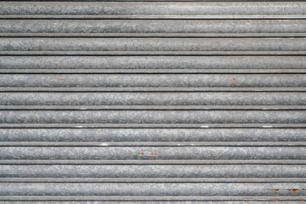 Pozadí starý vzor šedé oceli kyvadlová roleta válcování kovová brána šedá kovová opona starobylé pozadí moderních dveří domů - Fotografie, Obrázek