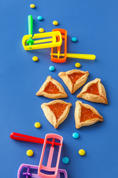 Hamantaschen galletas y sonajeros para Purim vacaciones sobre fondo de color - Foto, imagen