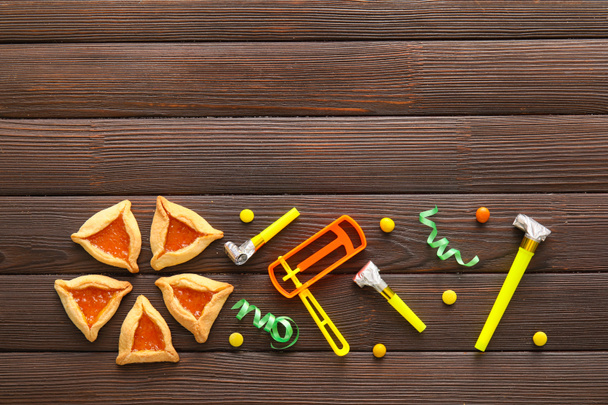 Hamantaschen μπισκότα και κουδουνίστρα για διακοπές Πουρίμ σε ξύλινο φόντο - Φωτογραφία, εικόνα