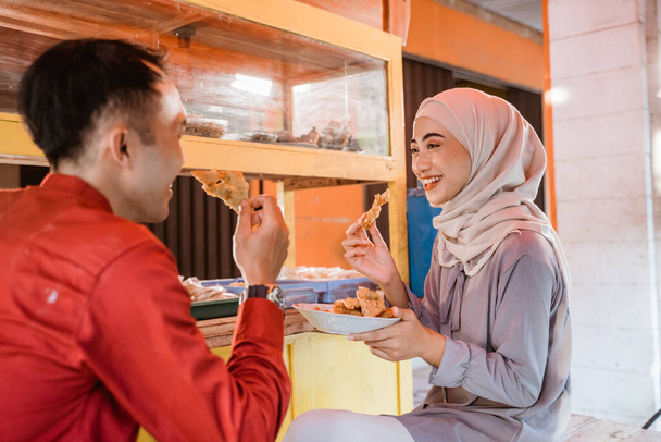 muslim couple sitting on traditional food stall, waiting for iftar time - Фото, зображення