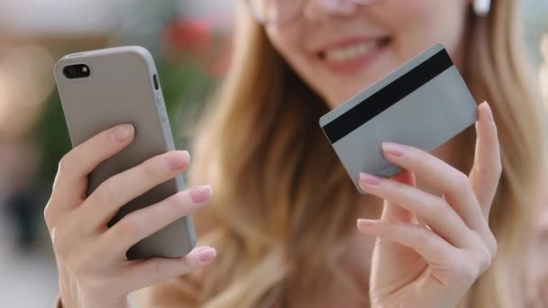 Close-up Hände junge kaukasische Mädchen mit Telefon und Kreditkarte Frau Käufer machen Internet-Bestellung mit modernen Gerät gibt Nummer für die Transaktion in App weiblich genießen fernen E-Commerce sichere Zahlung - Filmmaterial, Video