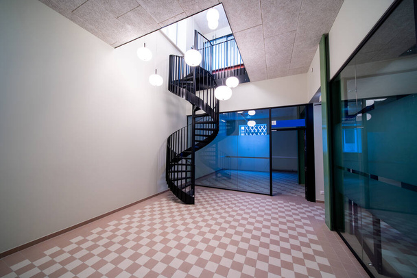 En un gran edificio que ha sido recientemente renovado, esta hermosa escalera de caracol se encuentra entre la planta baja y el primer piso - Foto, Imagen