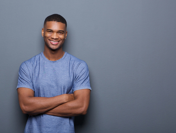 Homme noir souriant posant avec les bras croisés
 - Photo, image