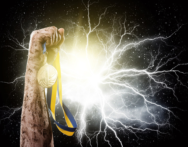 Hand held medal against a stormy sky - Photo, Image