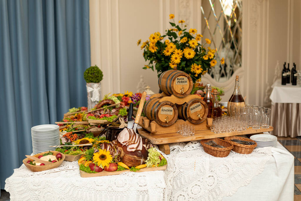 Όμορφα διακοσμημένο με λουλούδια και διακοσμήσεις, τραπέζι για νεόνυμφους σε γαμήλια τελετή στο εστιατόριο. Γαμήλια ανθοκομία. Κομψή πολυτέλεια. Γιορτινές εκδηλώσεις. Milosc για το βερνίκι σημαίνει αγάπη - Φωτογραφία, εικόνα
