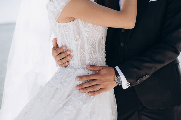 něžné objetí milujícího páru novomanželů na svatbě - Fotografie, Obrázek