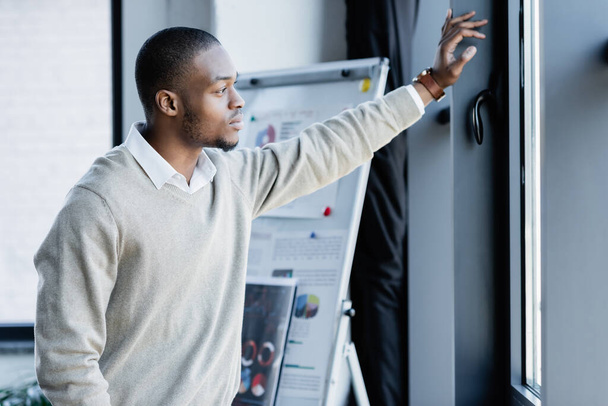 pensive african american man looking at window in office - Photo, Image