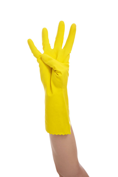 Концепция домашнего хозяйства - рука в желтой резиновой перчатке показывает четыре пальца изолированы на белом фоне - Фото, изображение